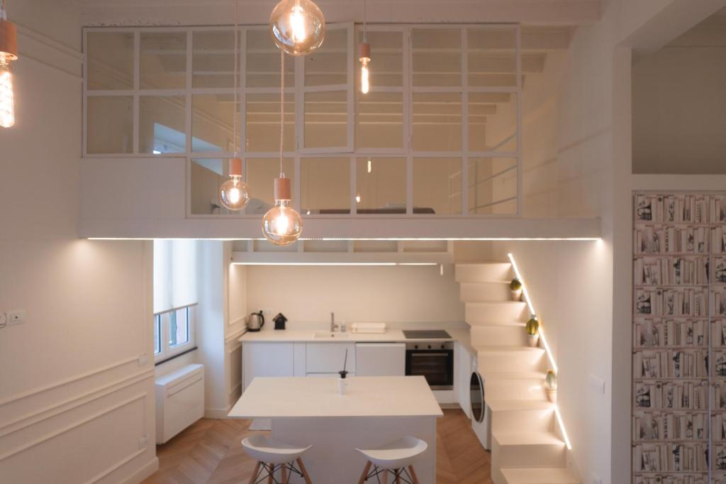 a kitchen and dining room with a table and stairs at Loft prestigioso nel centro di Sanremo in Sanremo