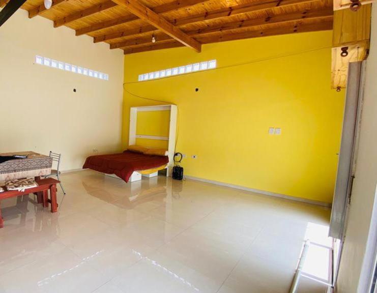 Habitación con cama y pared amarilla en Espacio LORENZO en Arana