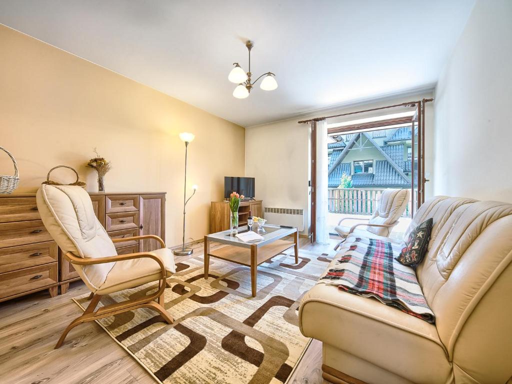 a living room with a couch and a table at VisitZakopane - Crocus Apartment in Zakopane