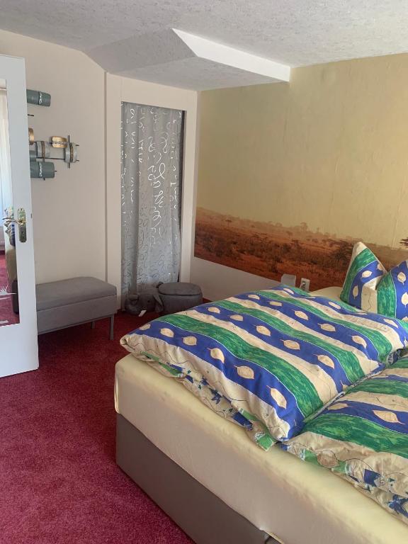 a bedroom with a bed with a colorful comforter and a window at Ferienhaus Annerose in Wendisch Rietz