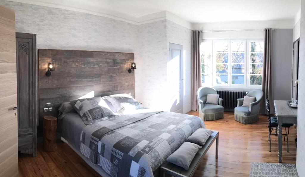 a bedroom with a bed and a desk and chairs at Les Rêves de Baie de Somme Chambres d'hôtes , Table d'hôtes et Spa in Béhen