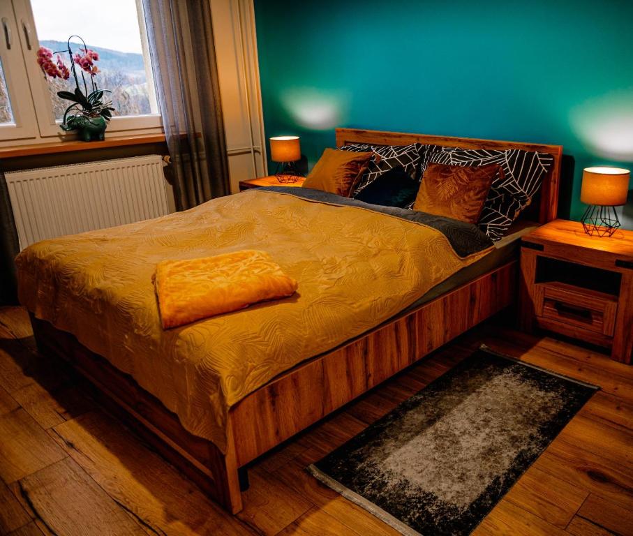 Un dormitorio con una cama con una manta amarilla. en Apartament blisko Czarnej Góry en Stronie Śląskie