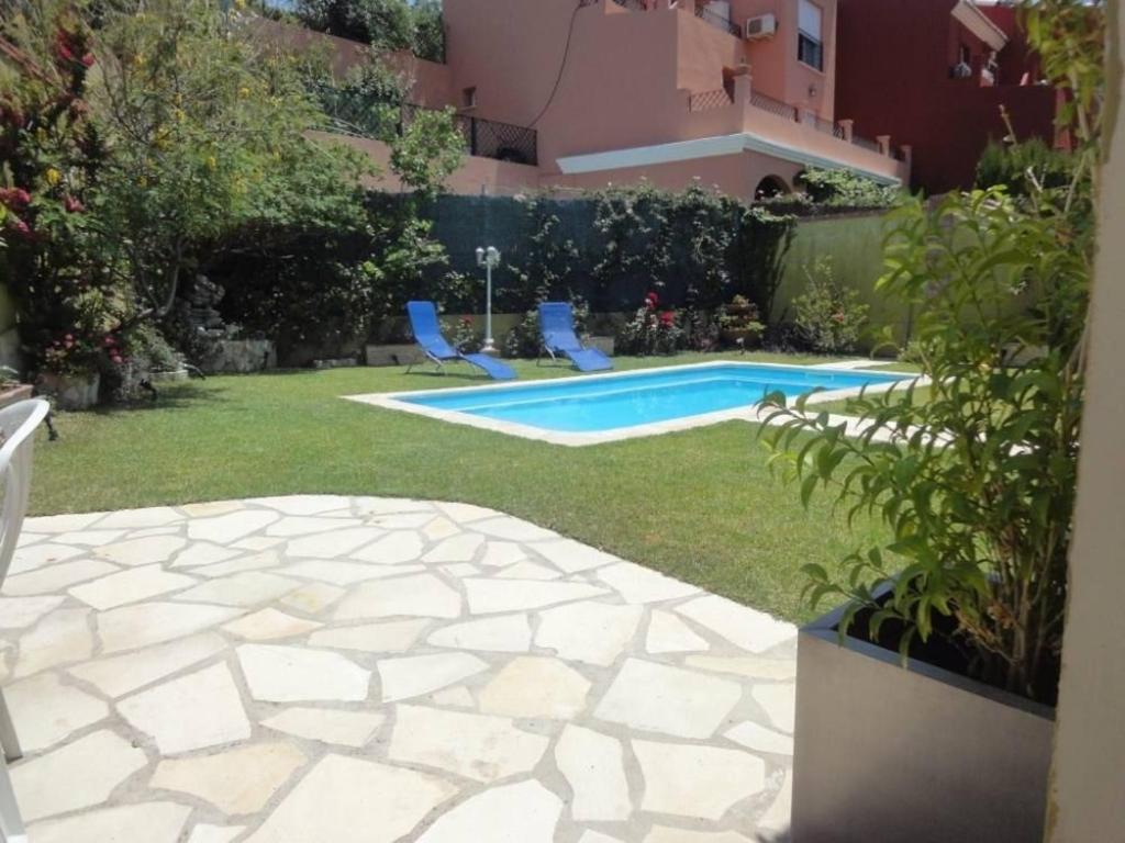 a backyard with a swimming pool and two blue chairs at Villa - 4 Bedrooms with Pool and WiFi - 01404 in Chilches