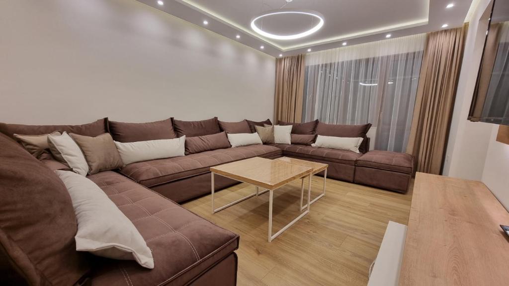 uma sala de estar com um sofá castanho e uma mesa em Guest House Gogemi em Bansko