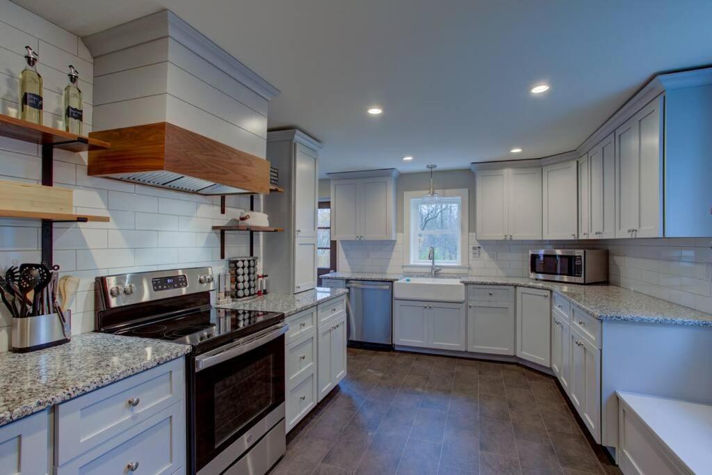 a large kitchen with white cabinets and appliances at Calla Lily Farmhouse in Manheim