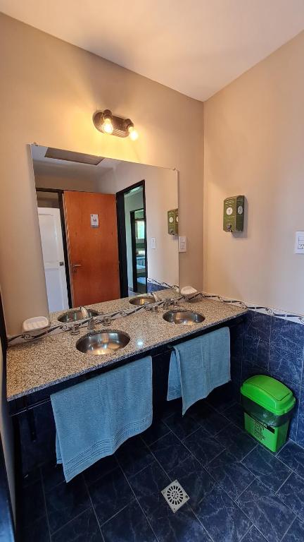 a bathroom with two sinks and a large mirror at Hostel I Keu Ken in El Calafate