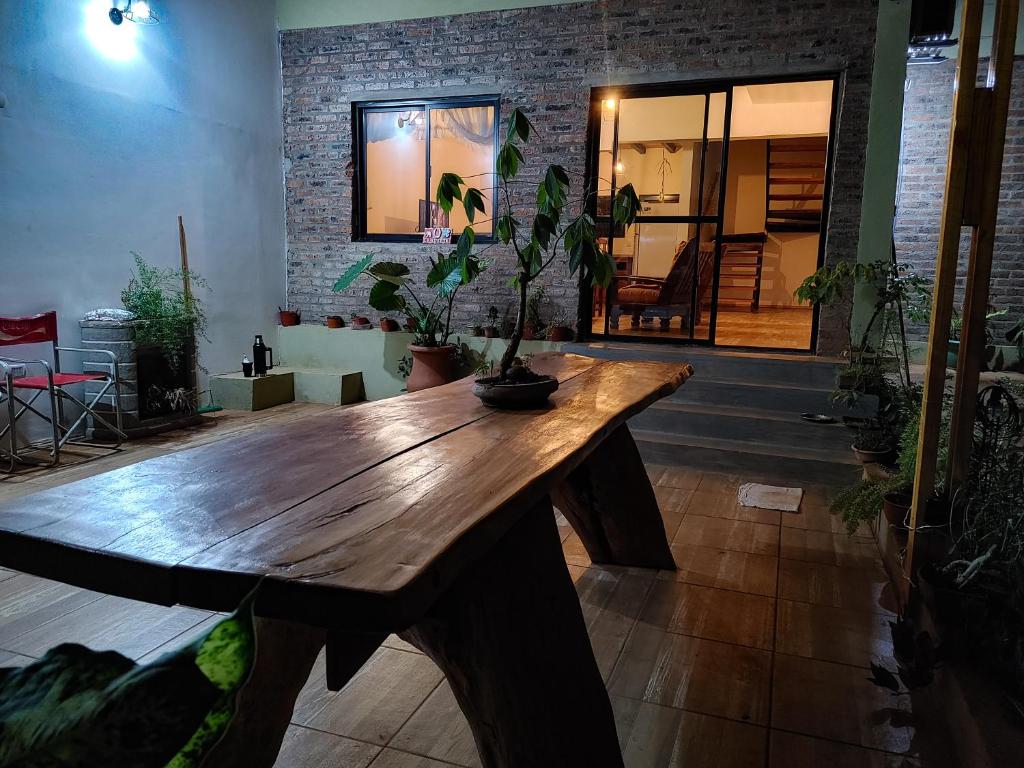uma mesa de madeira num quarto com vasos de plantas em Casa de Toto 3 habitaciones em Puerto Iguazú