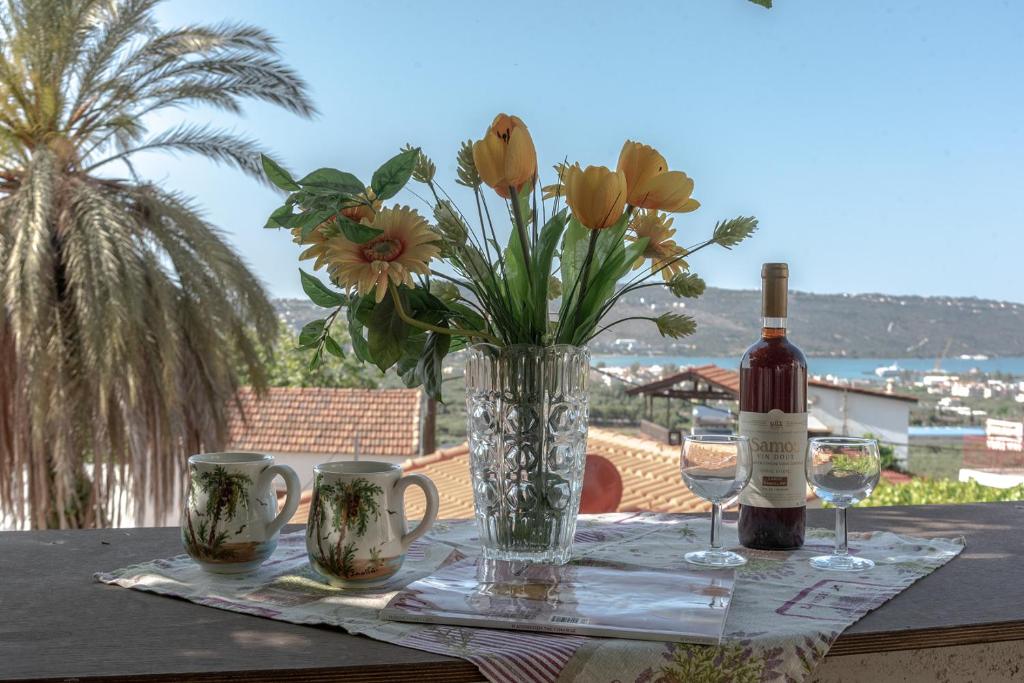 Tsikalariá的住宿－Michaela's House，一张桌子,上面放着花瓶和一瓶葡萄酒