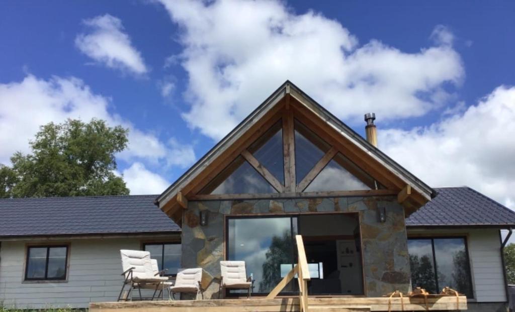Blockhaus mit Terrasse und Stühlen in der Unterkunft Bello Horizonte Lodge in Villarrica