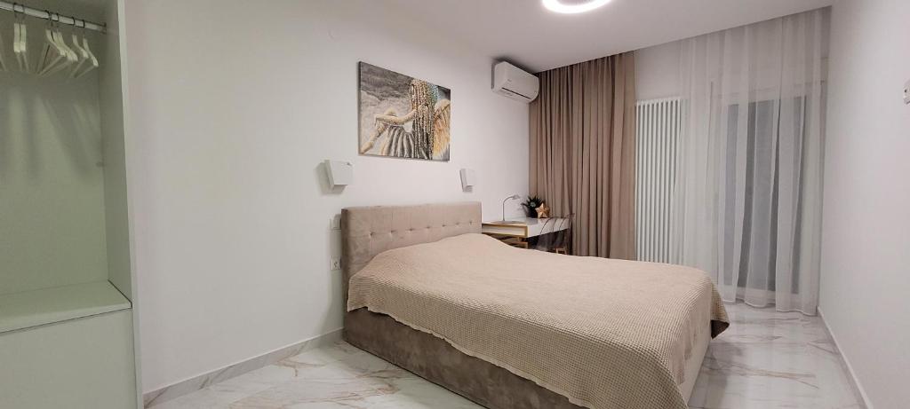 Un dormitorio con una cama en una habitación blanca. en Thessaloniki Harmony Life apartment, en Tesalónica