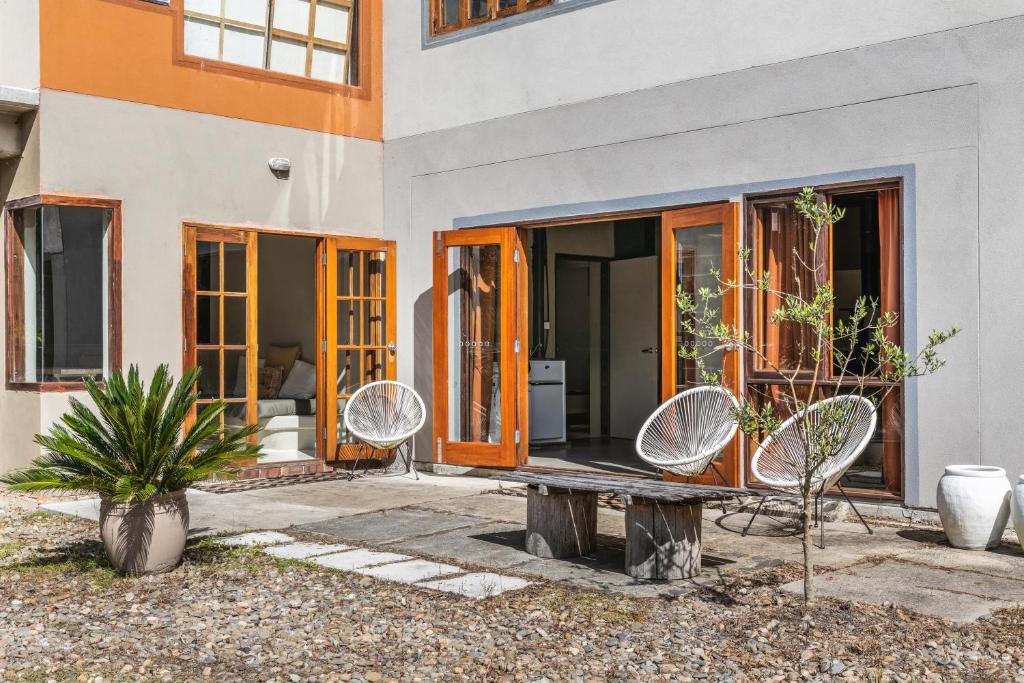 a house with a bench and chairs in front of it at Golden Streams in Conjola