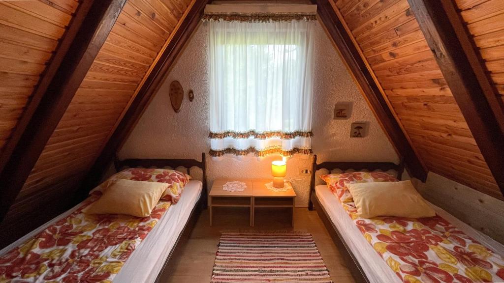 two beds in a small room with a window at Holiday home Bozica in Lokve