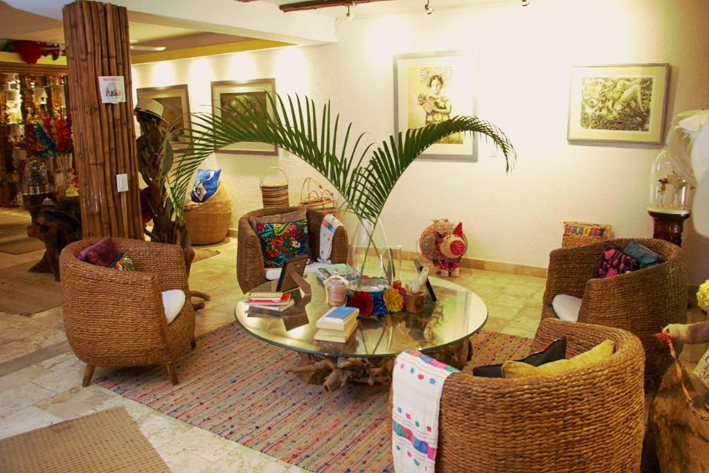 Casa Jaguar Hotel & Boutique في أكابولكو: غرفة معيشة مع طاولة وكراسي زجاجية