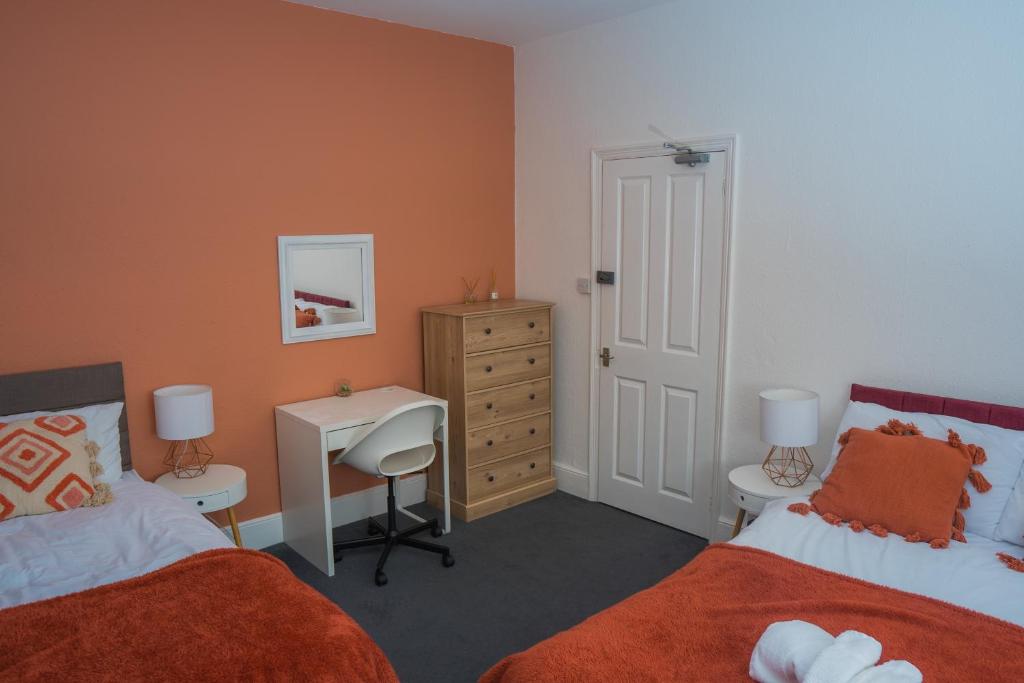 a bedroom with two beds and a desk and a dresser at The Private Villa, Northampton Centre, 9 Beds, 5 bedrooms, Sleeps 12 in Northampton