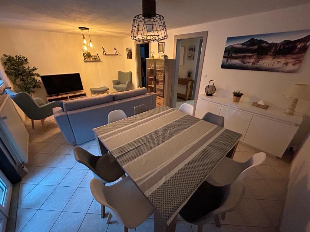une salle à manger avec une table et des chaises dans l'établissement Appartement de Camargaux 70m2 secteur très calme, à La Bresse