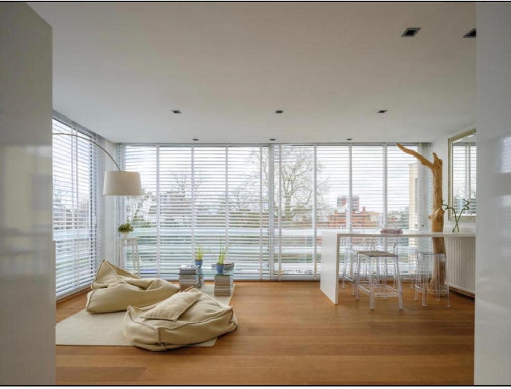 uma sala de estar com uma mesa e uma grande janela em Designloft em Gent