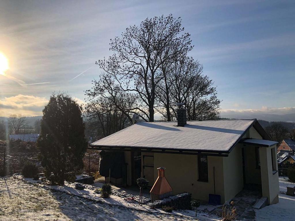 een klein huis met een tinnen dak in de sneeuw bij Chata V Lukách in Jablonec nad Nisou