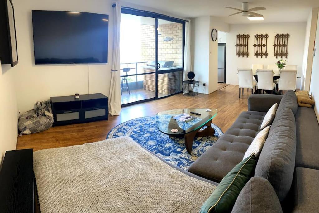 sala de estar con sofá y mesa en Manly family executive apartment en Sídney
