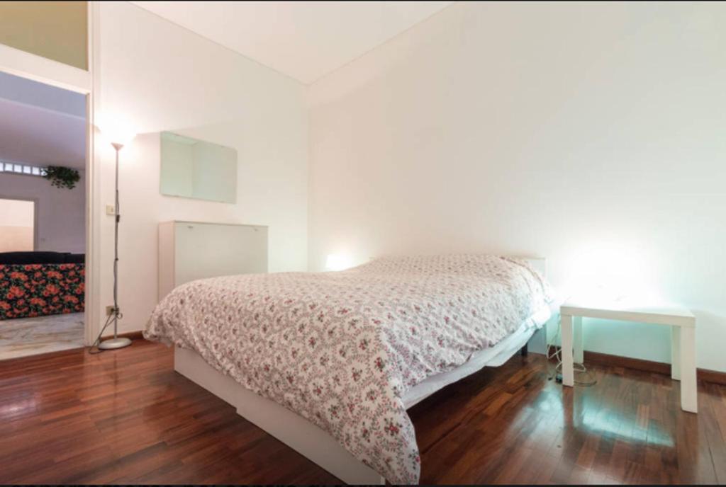 a white bedroom with a bed and a table at Santa Teresa in Turin