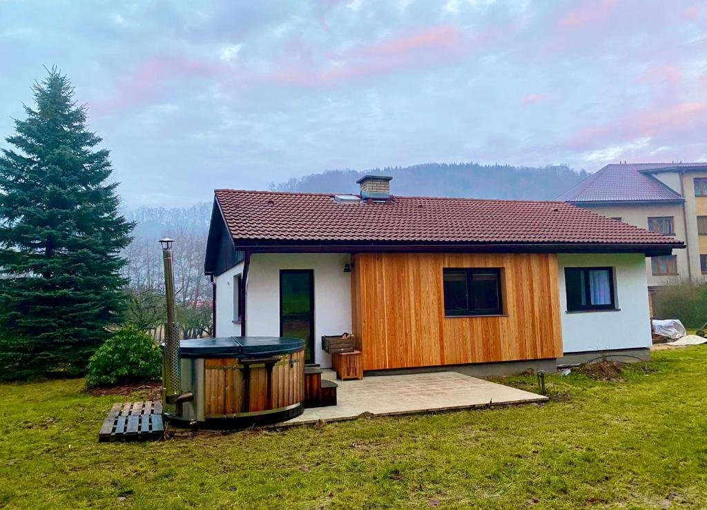 a small house in a yard with a tree at Chalupa 96 in Víchová nad Jizerou