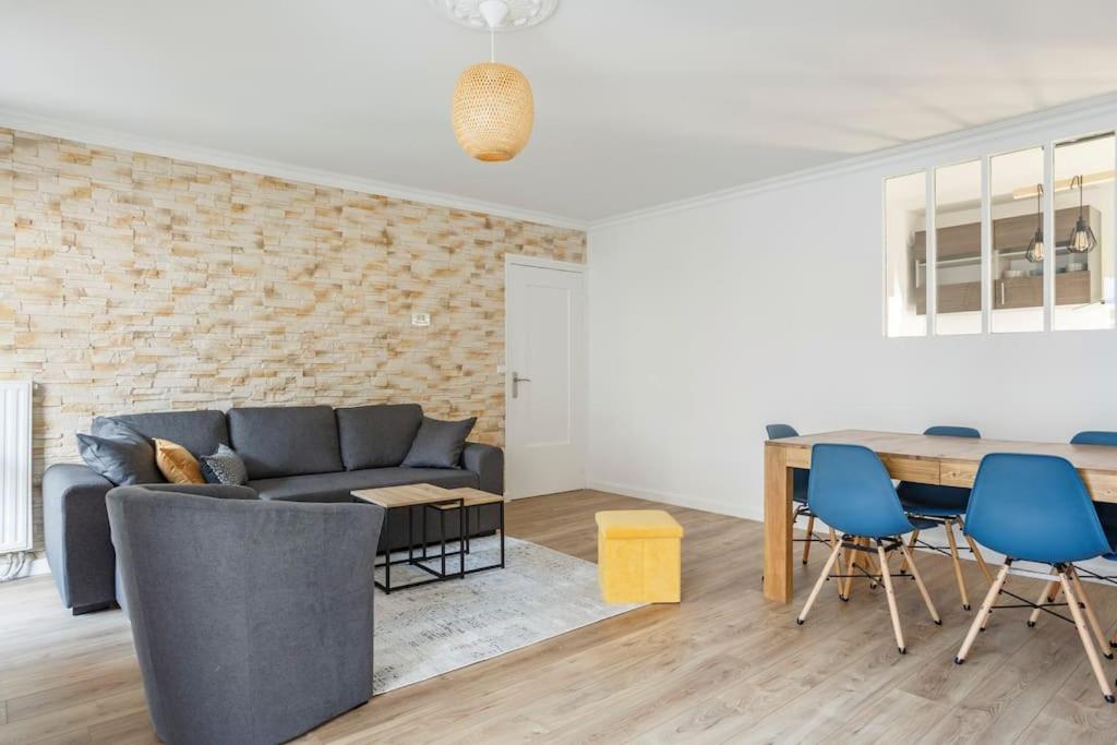 a living room with a couch and a table at Appart spacieux près de la Seine in Sartrouville