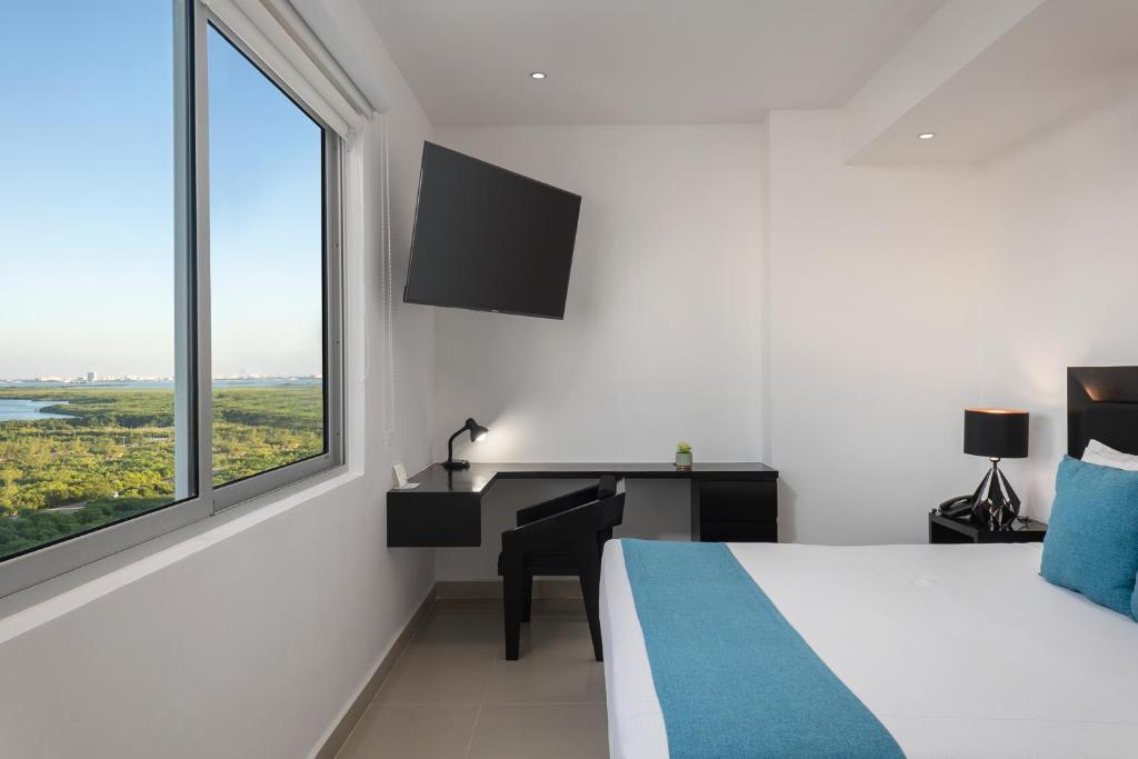 Cama ou camas em um quarto em Suites Malecon Cancun