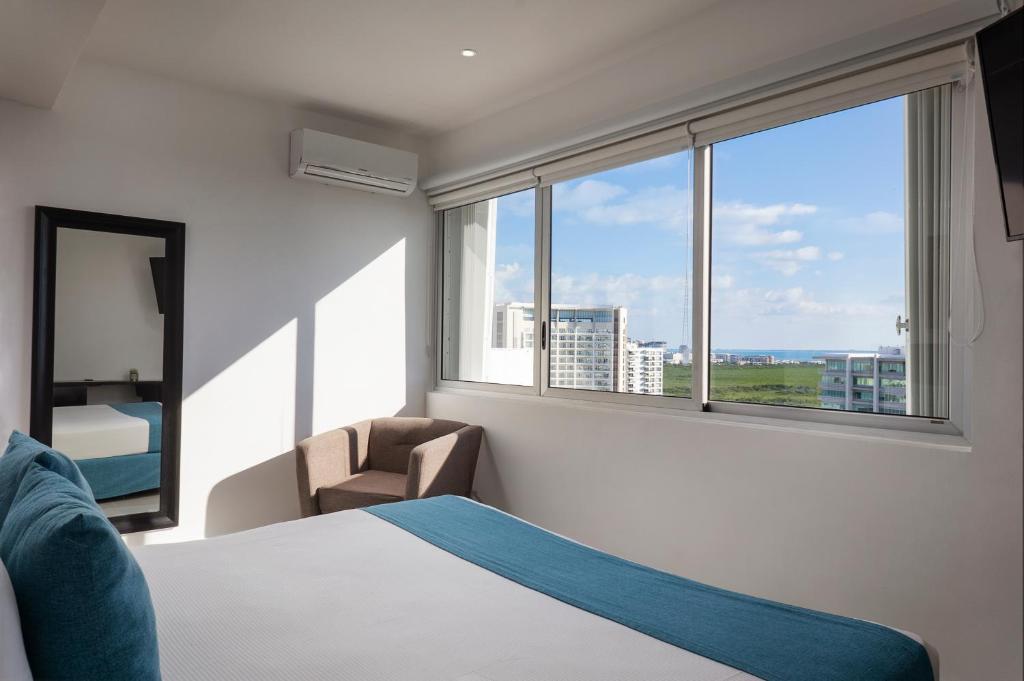 Cama ou camas em um quarto em Suites Malecon Cancun