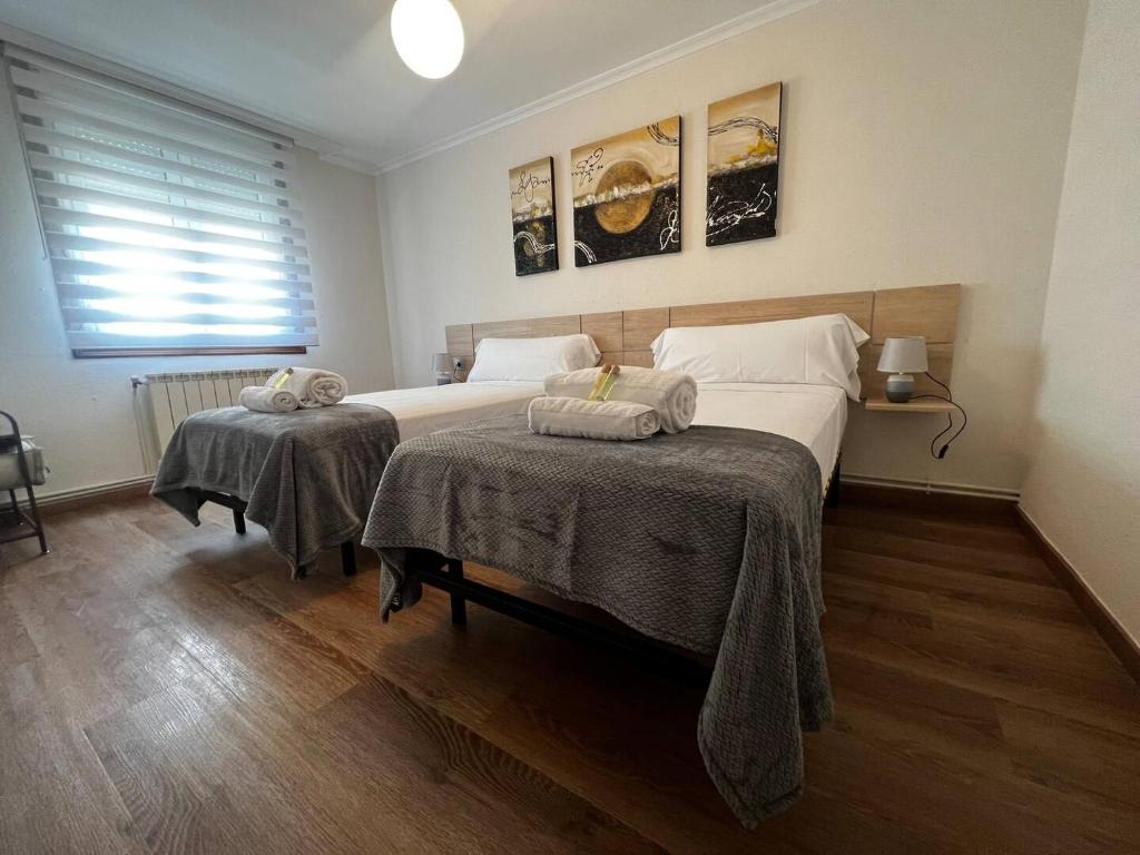 1 dormitorio con 2 camas y toallas. en Castiñeiras Street, en Sarria