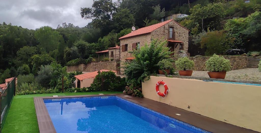 a villa with a swimming pool in front of a house at Quinta da Costeira in Sever do Vouga