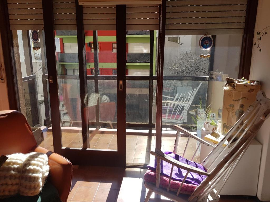 een kamer met een glazen schuifdeur en een balkon bij Departamento cerca de la playa in Mar del Plata