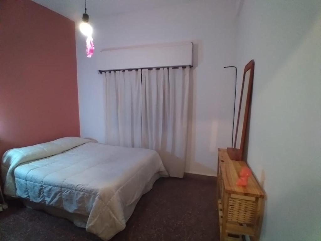 Dormitorio pequeño con cama y mesa en depar planta baja en Santa Teresita
