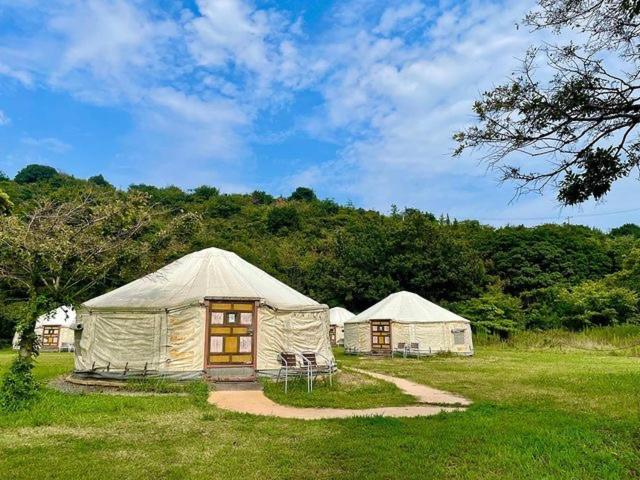 um grupo de tendas num campo de relva em 直島町ふるさと海の家 つつじ荘 -SeaSide Park Stay Tsutsujiso- em Naoshima