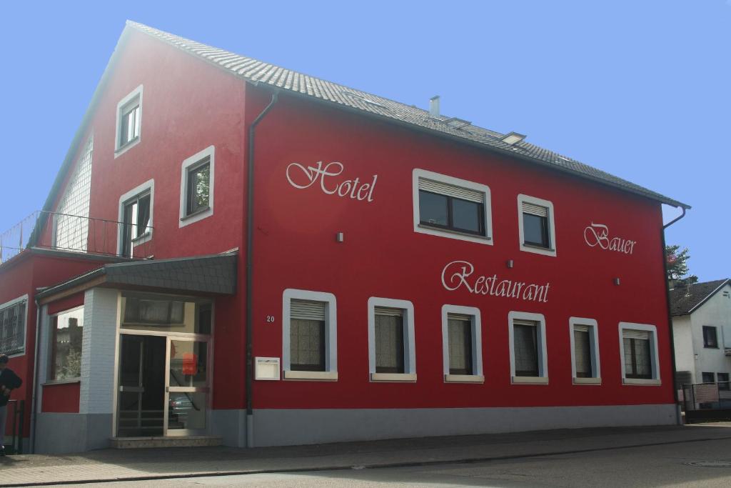 Hotelrestaurant Bauer في ساندهايسن: مبنى احمر مع الكلمات الراسمالية الجذرية مرسومة عليه