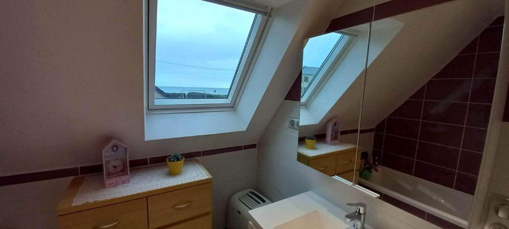 a bathroom with a sink and a window at Les villégiatures de Muse in Saint-Marcouf