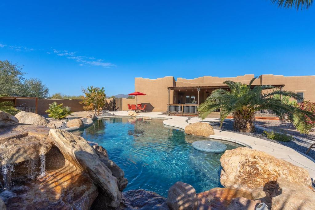 een zwembad in een achtertuin met een waterval en rotsen bij Cozy quiet home BBQ Pool Outdoor entertaining in Phoenix