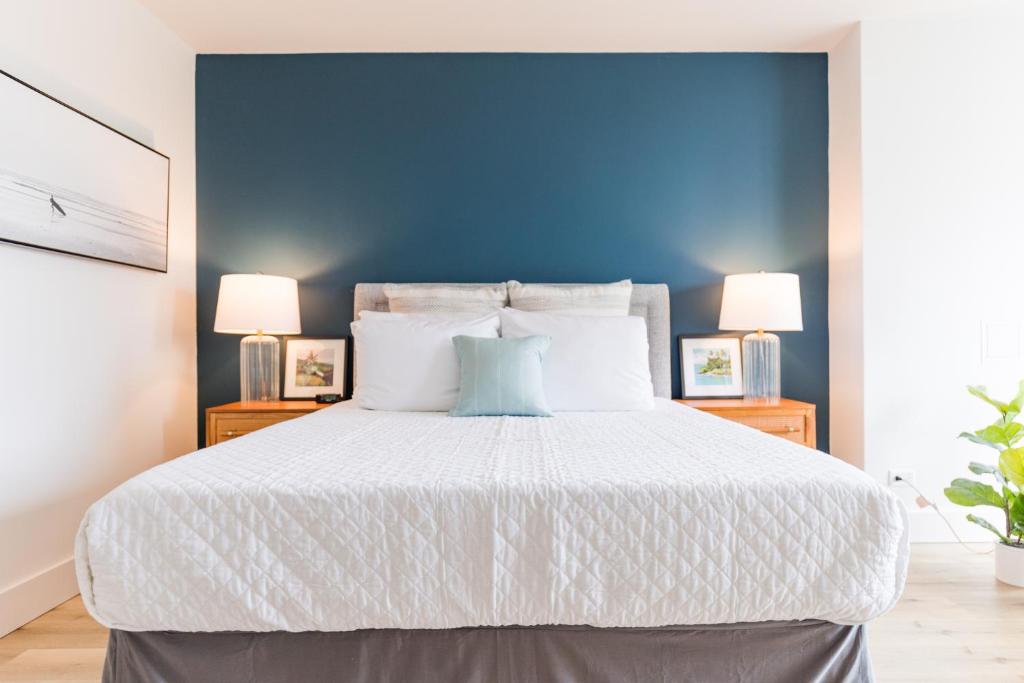 a bedroom with a large bed with a blue wall at Ilikai Marina Vacations in Honolulu