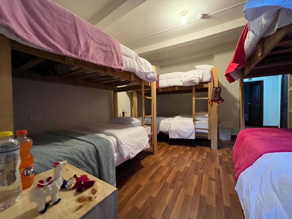 Cette chambre comprend 2 lits superposés et une table. dans l'établissement The Sleepy Mouse, à Cusco