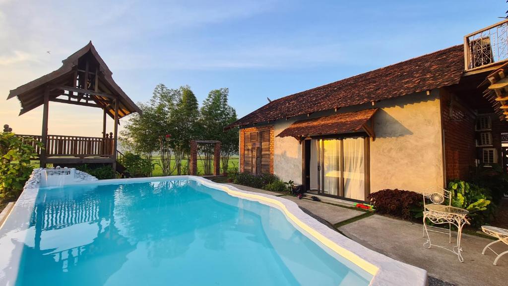 a swimming pool in front of a house at Classic Traditional Villa with Breathtaking View Pool WIFI in Pantai Cenang
