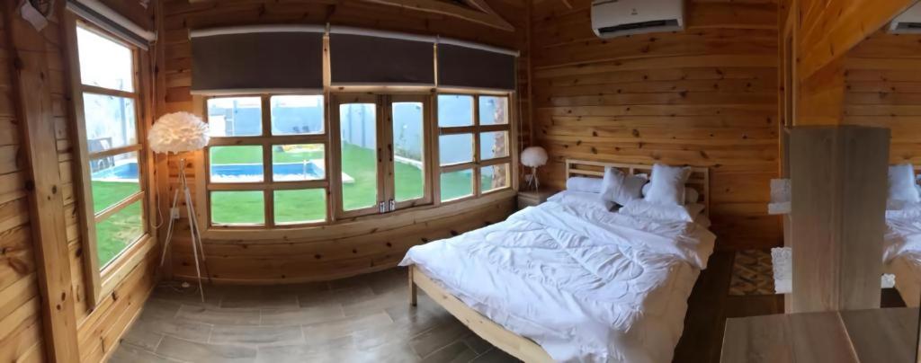 a bedroom with a bed in a wooden cabin at شاليهات ريموندا الريفيه الطائف in Taif