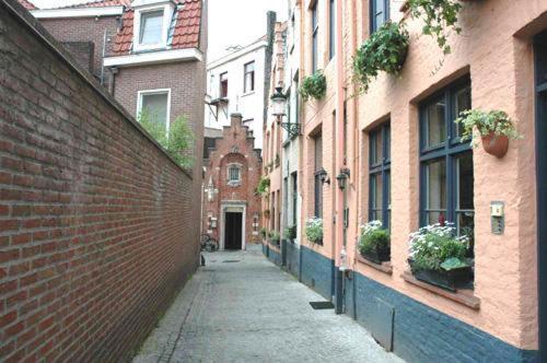 un callejón con edificios y una pared de ladrillo en Hotel Leopold en Brujas
