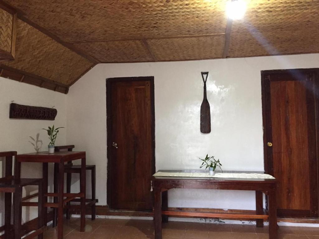 Habitación con 2 puertas de madera y mesa. en SHALOM CAMP, en El Nido
