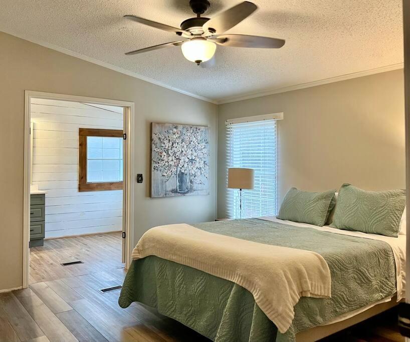 - une chambre avec un lit et un ventilateur de plafond dans l'établissement Rustic Relaxation Home! Spacious and Private, 