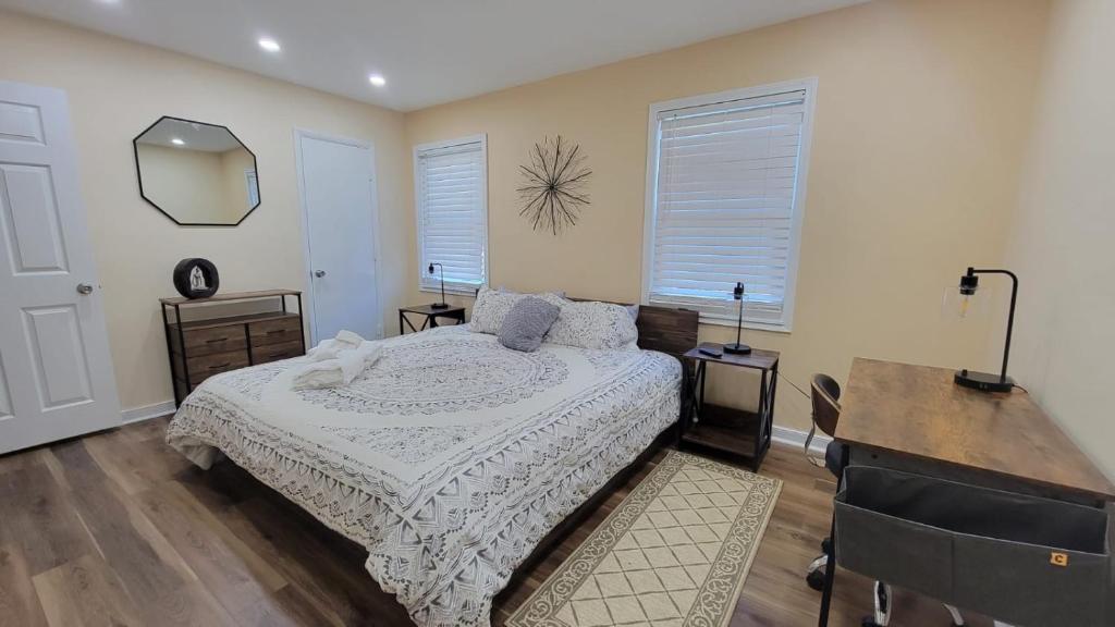 a bedroom with a bed and a desk and two windows at HHI Homes LLC in Hilton Head Island