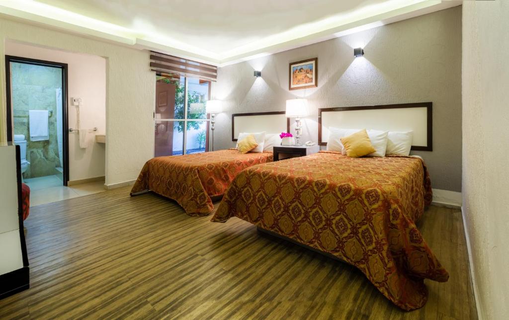 una habitación de hotel con 2 camas en una habitación en Hotel del Valle Inn, en Pachuca de Soto