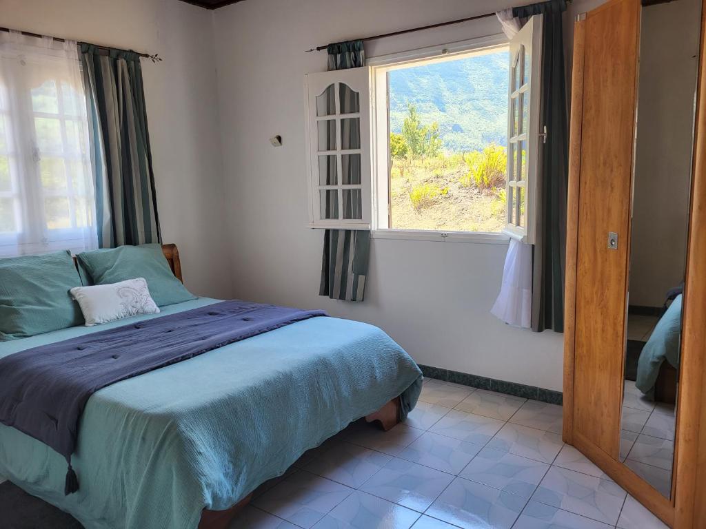 1 dormitorio con cama y ventana en Maison Créole Soalaze, en Salazie