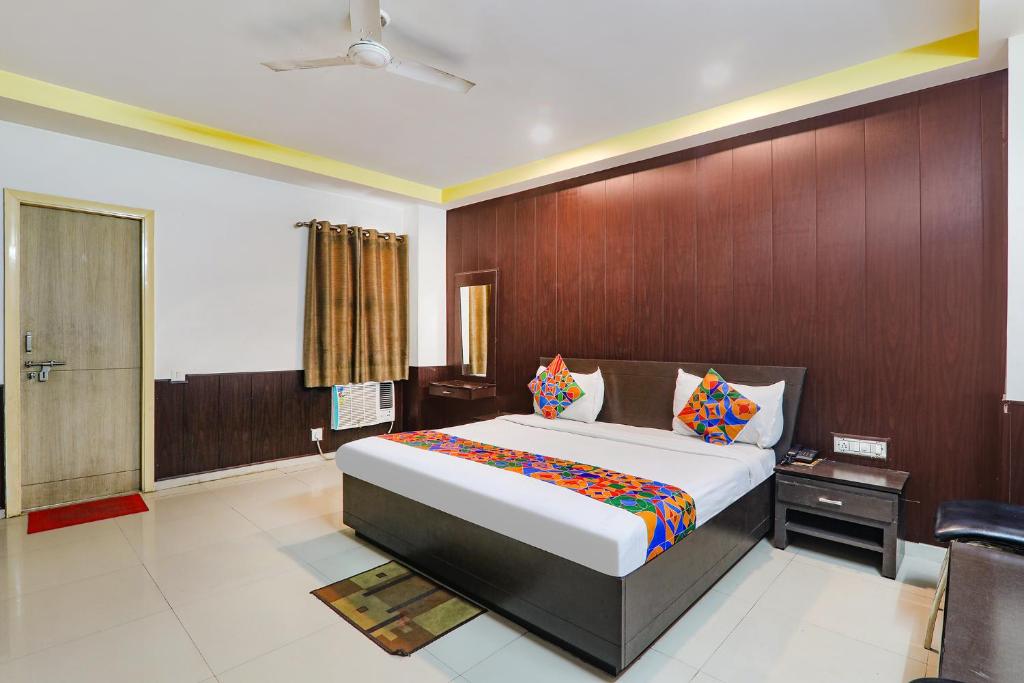 a bedroom with a large bed and a wooden wall at FabHotel PS International in Lucknow