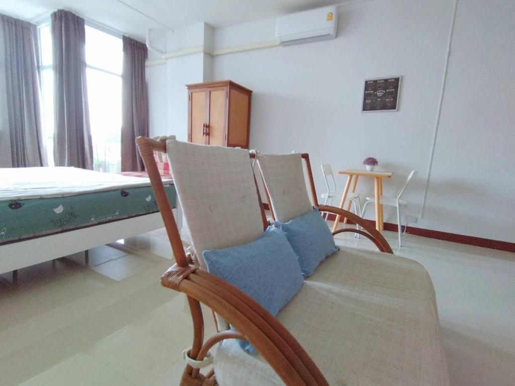 une salle d'hôpital avec un lit et deux chaises dans l'établissement Supanich condo opposite the Train Station ChiangMai, à Chiang Mai