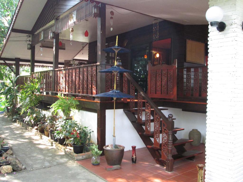 un escalier dans une maison avec des plantes et des parasols dans l'établissement Happiness Resort Sukhothai, à Sukhothaï