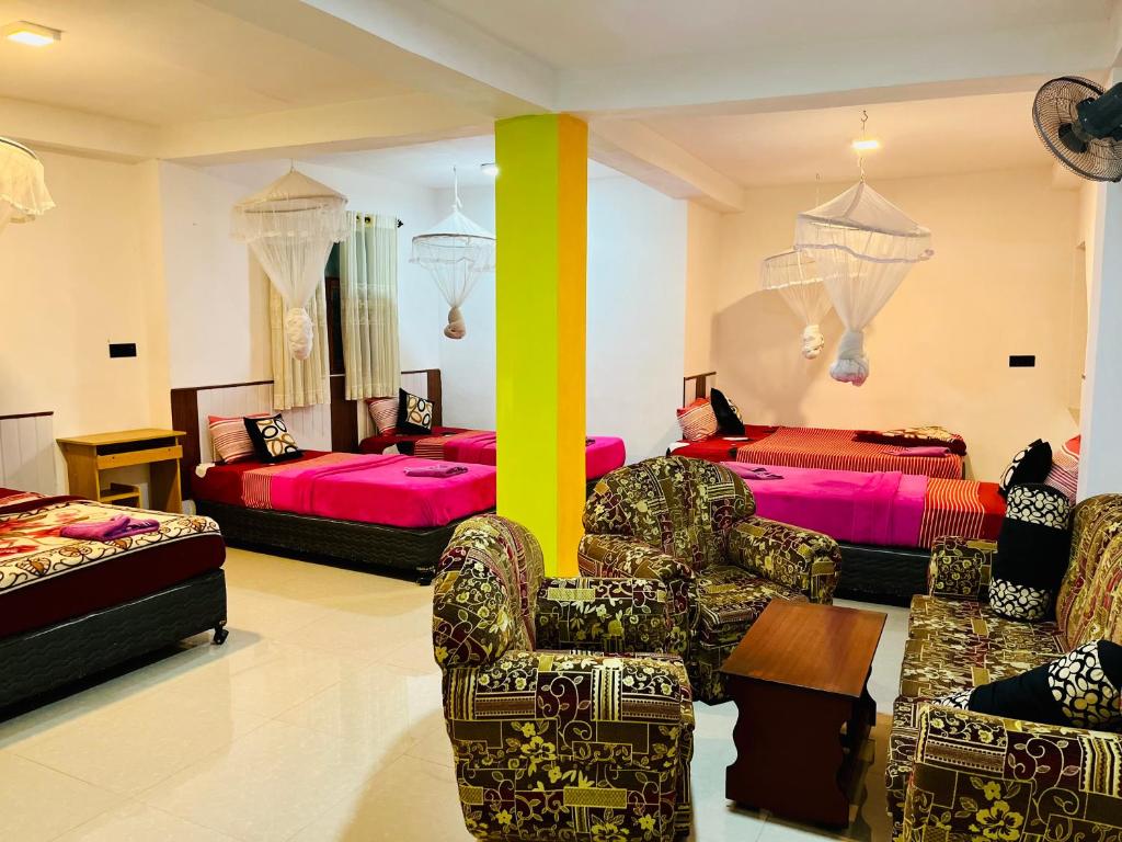 uma sala de estar com duas camas e duas cadeiras em Grand Adamspeak em Nallathanniya