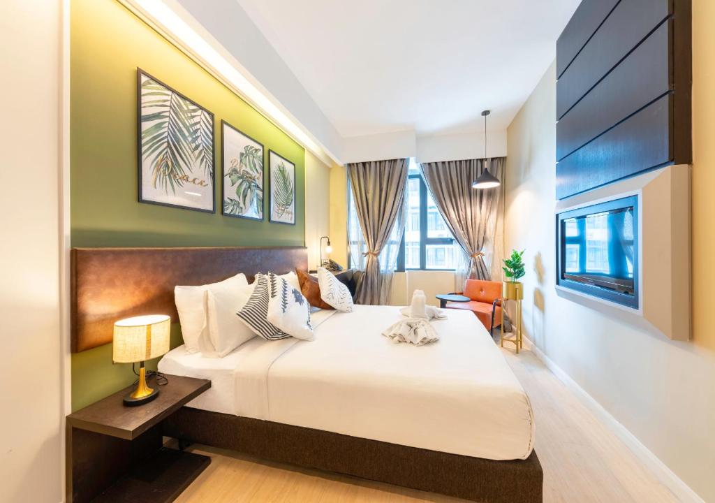 a hotel room with a bed and a tv at Greystone Centrestage PJ in Petaling Jaya